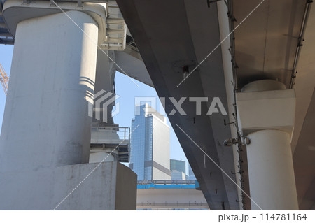 Overpasses on the background of skyscrapers. Blue sky and bright sun. Transport interchanges 114781164