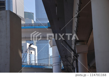 Overpasses on the background of skyscrapers. Blue sky and bright sun. Transport interchanges 114781168