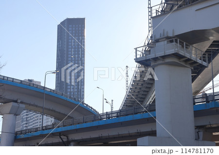 Overpasses on the background of skyscrapers. Blue sky and bright sun. Transport interchanges 114781170