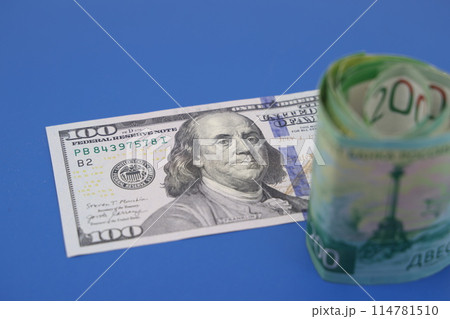 Russian rubles on background of US dollars. Concept of exchange rate, sanctions, falling ruble. 114781510