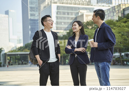 young asian adults standing talking on street young asian adults standing talking on street 114783027