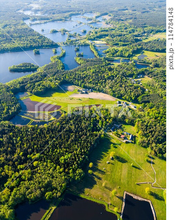 beautiful artificial lake in green forest, serene fishing pond and swamp, fishery and hunting industry, aerial top view, Osowek Poland beautiful artificial lake in green forest, serene fishing pond and swamp, fishery and hunting industry, aerial top view, Osowek Poland 114784148