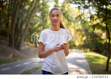Confident female jogger listening to music in Confident female jogger listening to music in 114784723