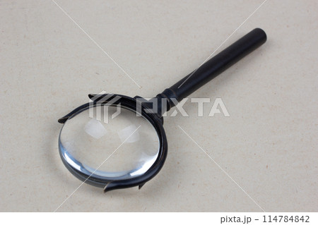 Antique magnifying glass on paper 114784842