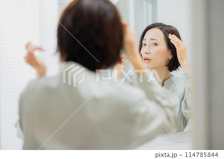 洗面所で鏡を見る女性 洗面所で鏡を見る女性 114785844
