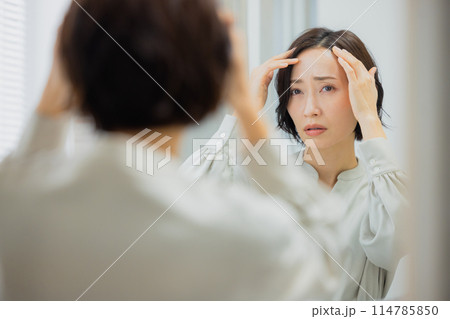 洗面所で鏡を見る女性 洗面所で鏡を見る女性 114785850