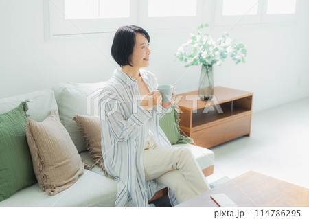 自宅でくつろぐミドル女性　 114786295