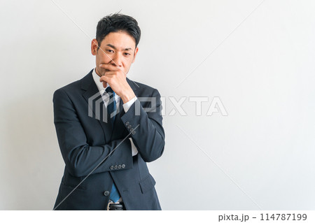 腕組みして考えるスーツ姿のアジア人中年ビジネスマン(悩む・困る・悩み・策士・戦略・作戦・検討) 腕組みして考えるスーツ姿のアジア人中年ビジネスマン(悩む・困る・悩み・策士・戦略・作戦・検討) 114787199