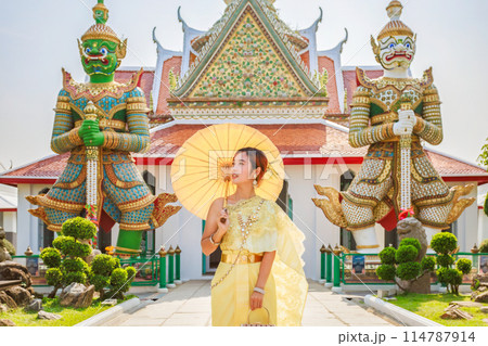 Asian tourists wearing the original traditional Thai costume Standing and taking pictures on the pagoda in Wat Arun Ratchawararam Ratchawaramahawihan. which is a popular tourist attraction in Bangkok, Asian tourists wearing the original traditional Thai costume Standing and taking pictures on the pagoda in Wat Arun Ratchawararam Ratchawaramahawihan. which is a popular tourist attraction in Bangkok, 114787914