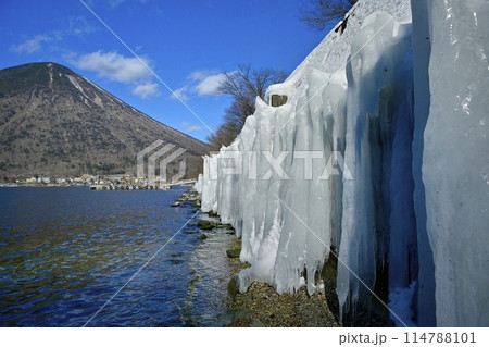 中禅寺湖東岸歌ヶ浜のしぶき氷の壁に男体山 114788101