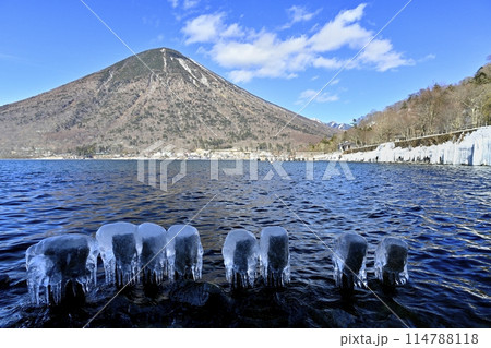 中禅寺湖東岸歌ヶ浜のしぶき氷に男体山 114788118