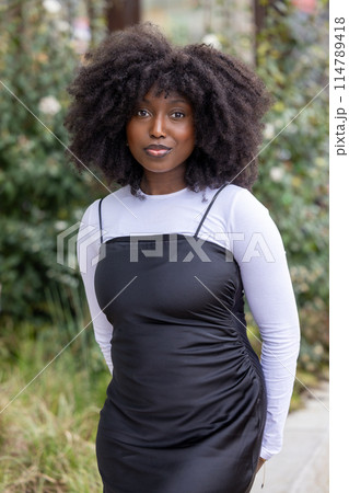 Black Woman in Black Dress and White Top Posing Outdoors Black Woman in Black Dress and White Top Posing Outdoors 114789418