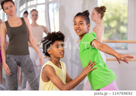 African American teen girl and boy learning paired ballet technique African American teen girl and boy learning paired ballet technique 114789692