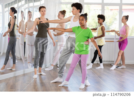 African American teenage girl practicing ballet moves with boy 114790206