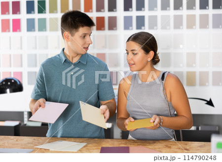 Married couple discussing ceramic tile colors in hardware store 114790248