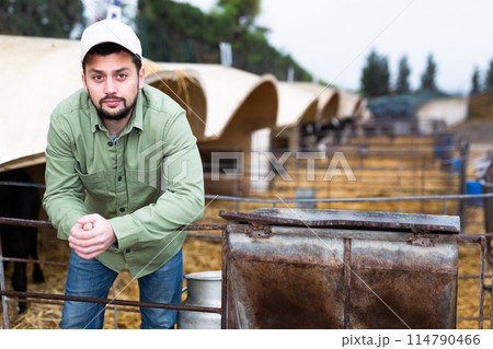 Confident young farmer standing in open stall in livestock farm 114790466