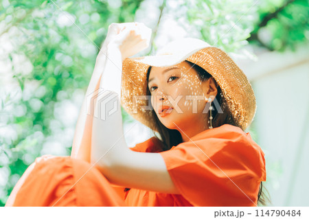 麦わら帽子をかぶる若い女性 114790484