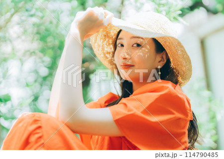 麦わら帽子をかぶる若い女性 114790485