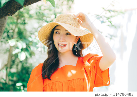 麦わら帽子をかぶる若い女性 114790493