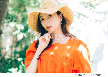 麦わら帽子をかぶる若い女性 114790495