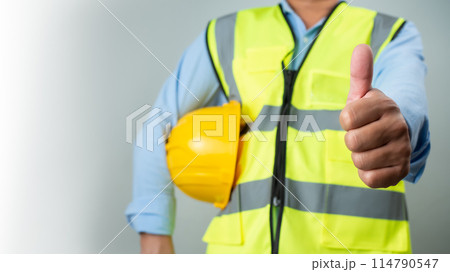 Civil engineer architect standing holding a safety helmet on grey background, Construction site plans to build high-rise buildings, Engineer building concept, Background for construction. 114790547