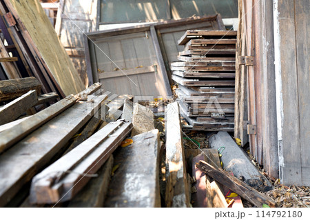 Old wooden plank, window and door are scattered in a disorganized pile. 114792180