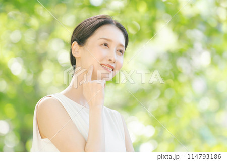 新緑の中でリラックスする女性 114793186