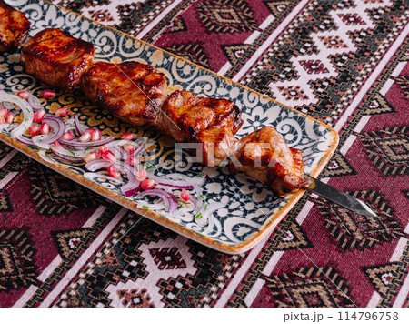 Traditional grilled meat skewers on ornate plate 114796758