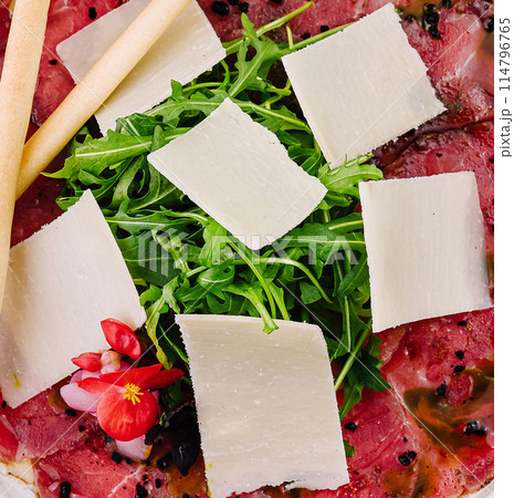 Fresh beef carpaccio with arugula and parmesan 114796765