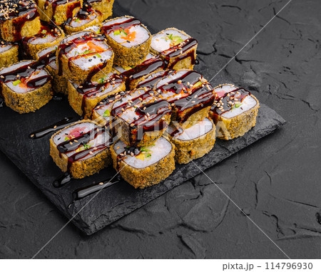 Delectable sushi rolls platter on dark slate background 114796930