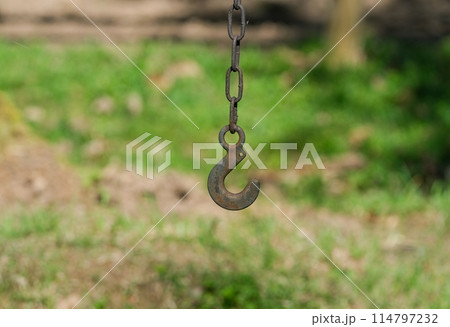 Rusty Hook Hanging from Chain Outdoors Rusty Hook Hanging from Chain Outdoors 114797232