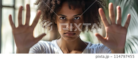 African American woman in a white t shirt shows refusal and disgust with her hands signaling to stop 114797455