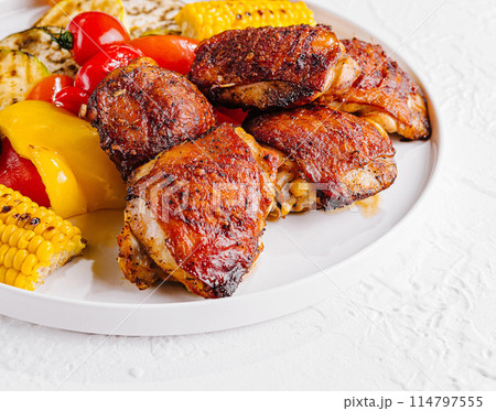 Grilled chicken thighs with vegetables on plate 114797555