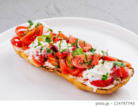 Fresh tomato and cheese bruschetta on plate 114797748