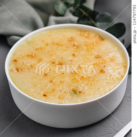 Creamy corn soup with herbal tea on gray table Creamy corn soup with herbal tea on gray table 114797793