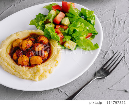 plate of nutritious meals with salad, grilled cutlet, and mashed potatoes on a stone background 114797821