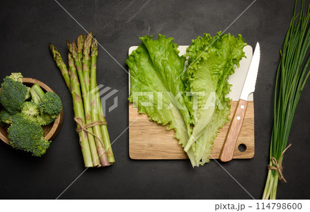 Raw asparagus, broccoli and spices on black background, top view Raw asparagus, broccoli and spices on black background, top view 114798600