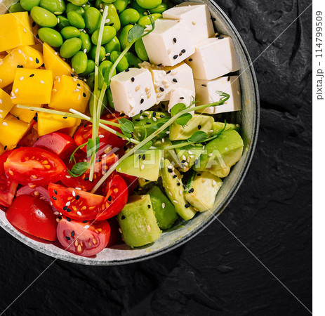 Fresh vegan poke bowl on dark slate background 114799509