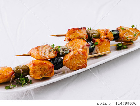 Gourmet grilled chicken skewers on white plate 114799636
