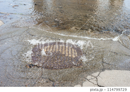 Water fountain pours out from sewer hatch, breakthrough sewerage system, accident of water supply Water fountain pours out from sewer hatch, breakthrough sewerage system, accident of water supply 114799729