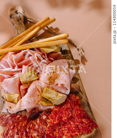 Gourmet charcuterie assortment on wooden board 114800059