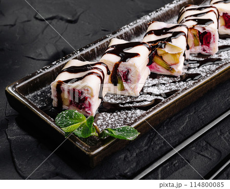 Gourmet fruit sushi rolls on elegant slate plate Gourmet fruit sushi rolls on elegant slate plate 114800085