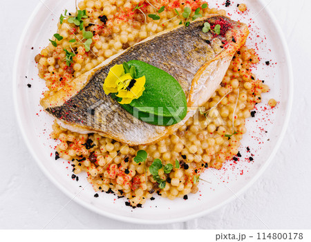 Grilled salmon fillet with herb couscous on plate 114800178