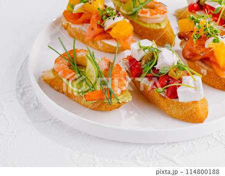 Elegant platter of assorted bruschetta with fresh toppings on a white background Elegant platter of assorted bruschetta with fresh toppings on a white background 114800188
