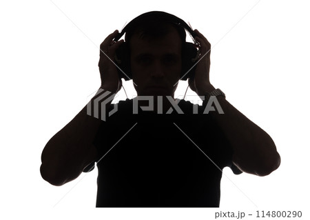 Silhouette of a young man with a smartphone with headphones 114800290