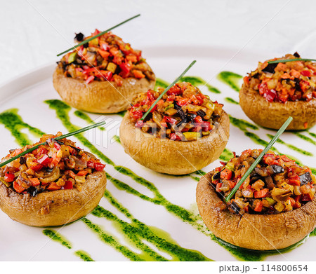 Gourmet stuffed mushrooms on elegant white plate 114800654