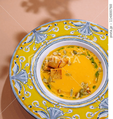 Vibrant pumpkin soup with croutons in decorative bowl Vibrant pumpkin soup with croutons in decorative bowl 114800760