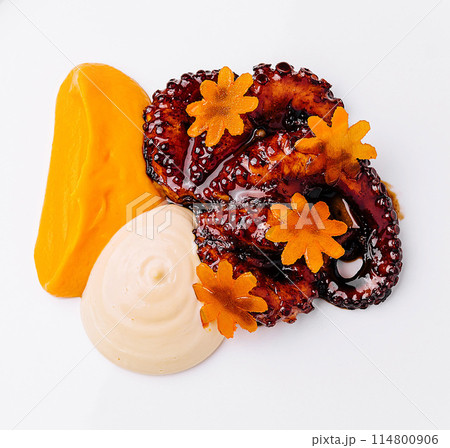 Gourmet octopus salad with carrot flowers on white plate 114800906