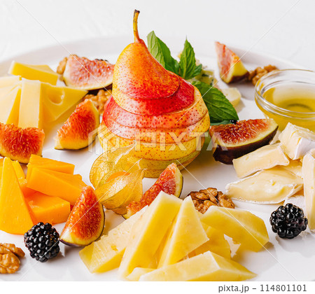 Gourmet cheese and fruit platter on white background Gourmet cheese and fruit platter on white background 114801101