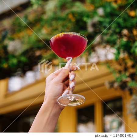 Elegant hand holding cocktail outdoors 114801407